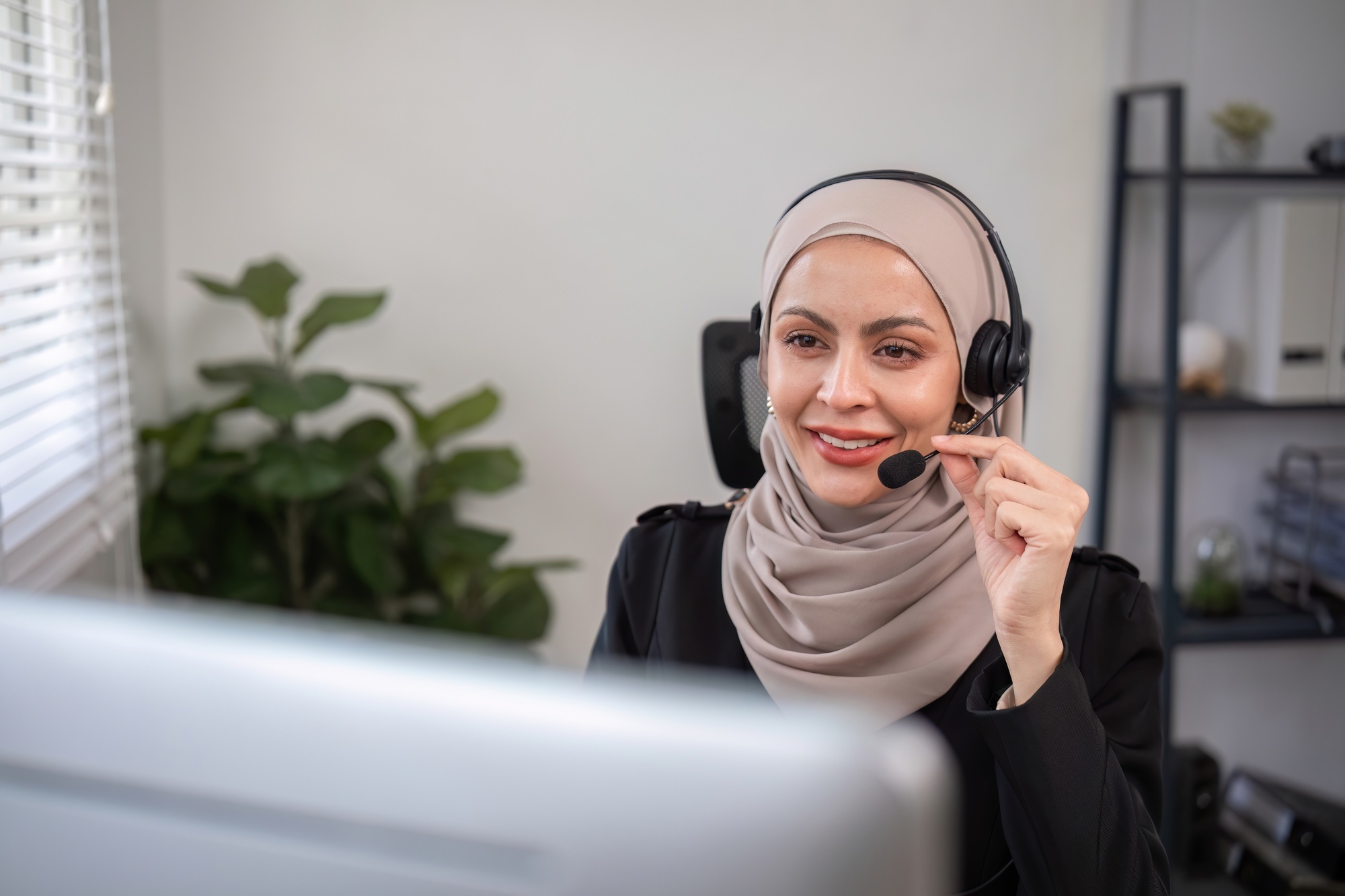 Muslim female call center employee wearing hijab Talking with customers on laptop in customer