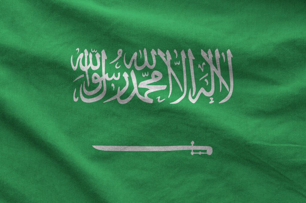 Saudi Arabia flag depicted on folded wavy fabric of old cloth
